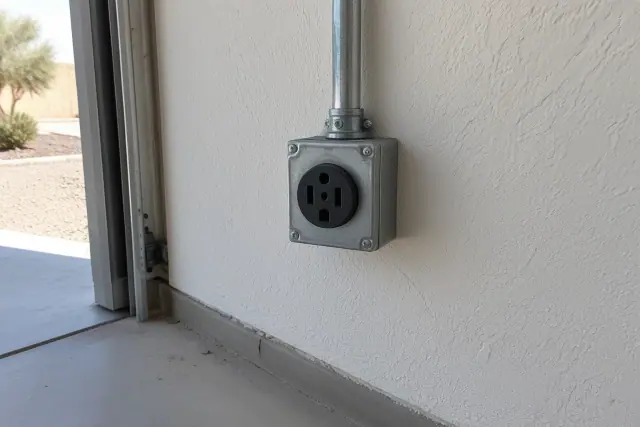 NEMA 14-50 EV charger outlet installation in Mesa, AZ, showing conduit and a metal junction box on a drywalled wall.