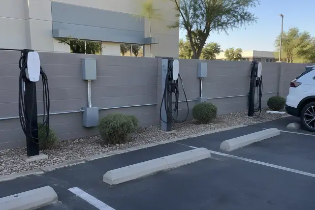 EV chargers with exposed conduit and hardware in an employee parking lot in Mesa, AZ.