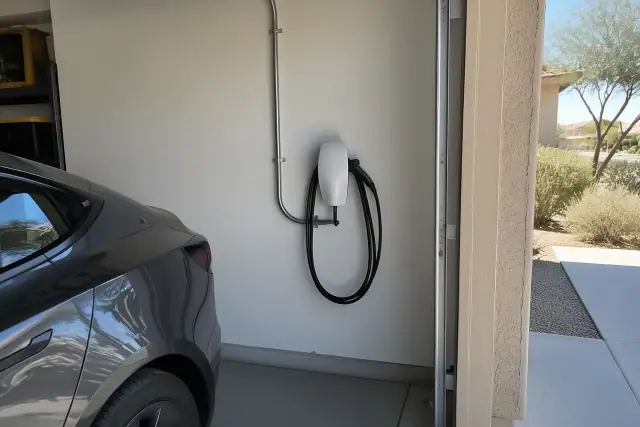 Tesla Wall Connector installation on a drywalled garage wall with conduit in San Tan Valley, AZ.