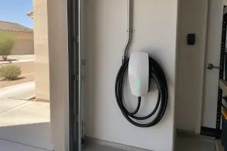 Hardwired Tesla Wall Connector on a drywalled garage wall in Mesa, AZ.