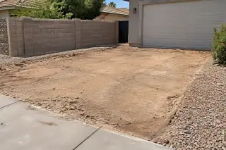Exposed subgrade and split-face block wall after concrete removal in Mesa, AZ.