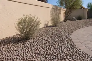Finished rock hauling project with Sonoran desert gravel and a stucco wall in Mesa, AZ.