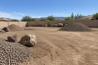 Freshly leveled earthen yard with decorative gravel and boulders in Mesa, AZ.