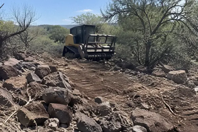 Heavy forestry mulcher clearing dense brush and rocky soil on a jobsite in Mesa, AZ.