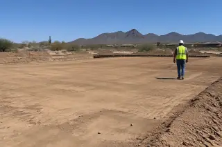 Contractor inspecting the finished building pad and cleanup in Mesa, AZ.