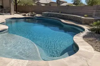 Completed backyard pool with fresh plaster and coping stones in Mesa, AZ.