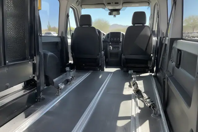 Accessible wheelchair transport van interior in Mesa, AZ, showing aluminum floor tracks and tie-down straps.