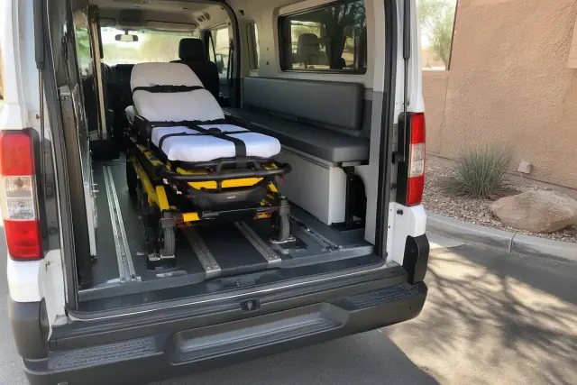 Stretcher and gurney transportation vehicle interior in Mesa, AZ, showing secure floor tracks and padded cushioning.