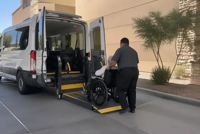 Ambulatory transportation vehicle with deployed wheelchair ramp at a hospital loading bay in Gilbert, AZ.
