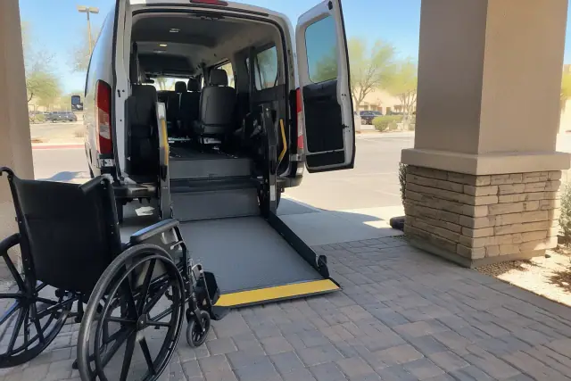 Ambulatory transportation vehicle at a job setting in Mesa, AZ, framed by desert stone pavers and a stucco pillar.