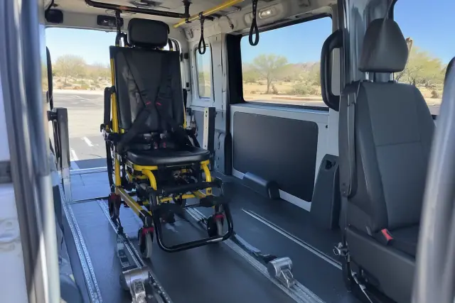 Interior of a transport van in Mesa, AZ, showing floor tracks and grab handles for bariatric stair chair transport.