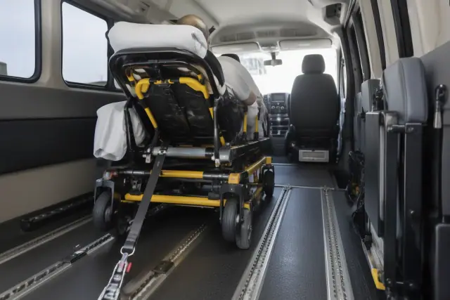Bariatric transport vehicle interior in Gold Canyon, AZ, showing secure floor tracks and an anchored restraint strap.