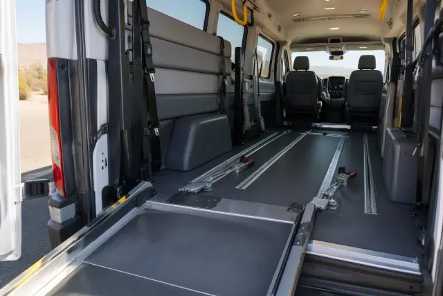 Bariatric transport van interior in Mesa, AZ, showing secure floor tracks, overhead grab handles, and a wheelchair ramp.