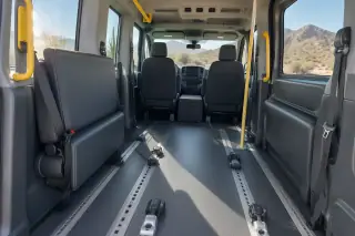 Arid hillside backdrop visible through the windows of a transport van interior in Mesa, AZ.