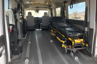 Padded transport van interior with desert dust on rubber floor mats in Mesa, AZ.