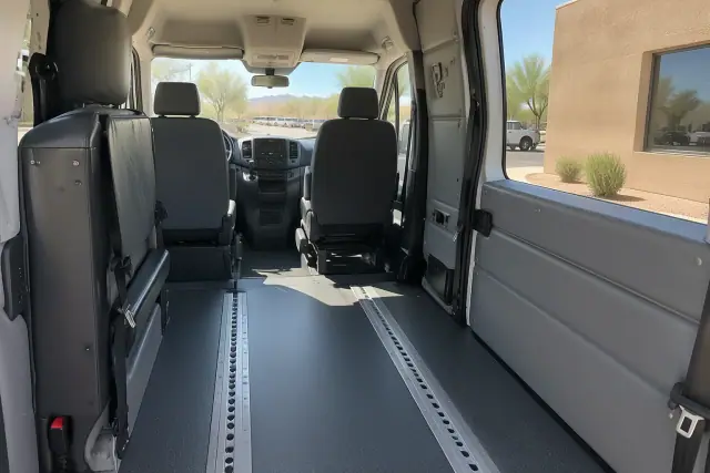 Behavioral health transport van interior cabin in Mesa, AZ, showing secure floor tracks and padded walls.