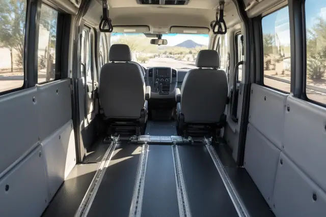 Behavioral health transport van interior in Sun Lakes, AZ, showing secure floor tracks and padded bulkhead anchors.