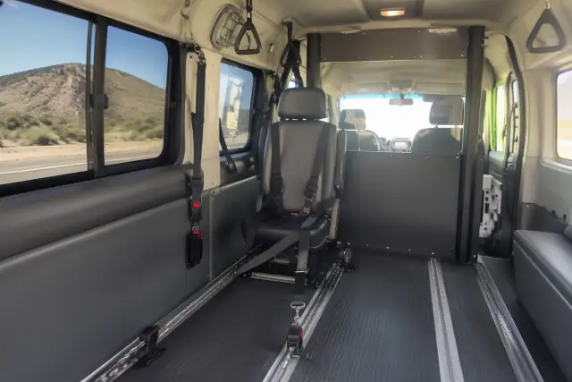 Behavioral health transport van interior with safety partition and securement straps in San Tan Valley, AZ.