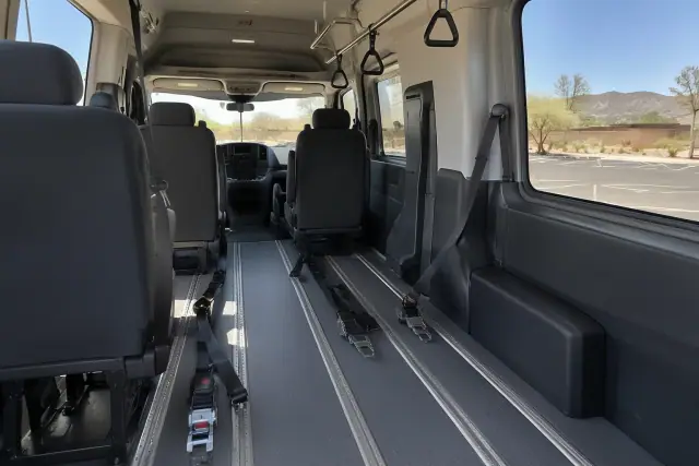 Padded interior of a behavioral health transport van with secure floor tracks in Gilbert, AZ.