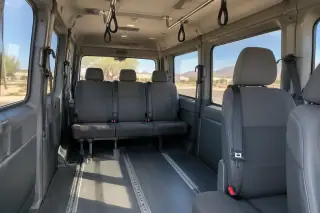 Padded vehicle interior with secure floor tracks and overhead grab handles in Mesa, AZ.