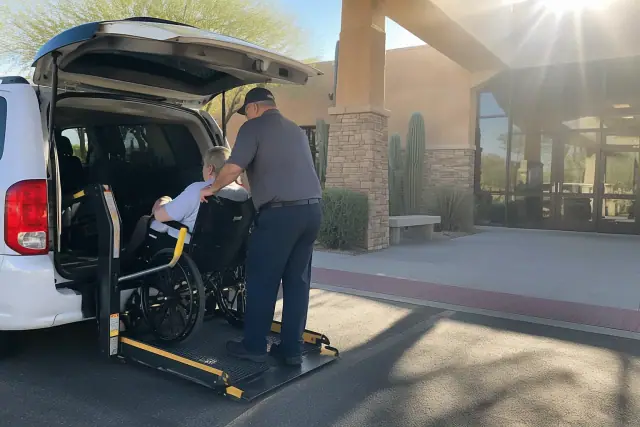 Chemotherapy transportation drop-off at a cancer center in Mesa, AZ, under desert sun glare.