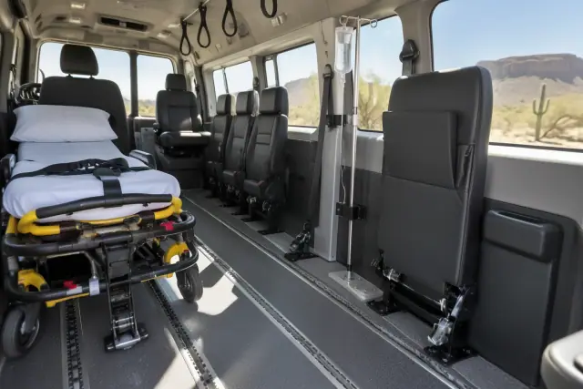 Padded medical transport interior with floor tracks and grab handles in Mesa, AZ.