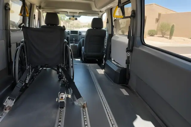 Wheelchair securement straps fastened to floor tracks inside a medical transport vehicle in Sun Lakes, AZ.