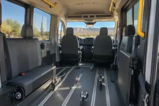 Tinted windows reflecting Sonoran desert sunlight inside a transport van in Mesa, AZ.