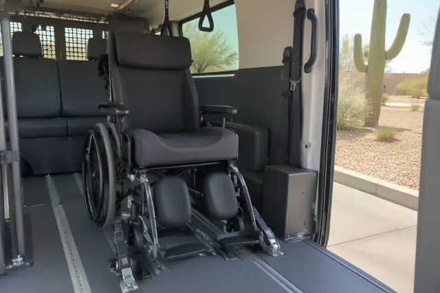 Wheelchair secured inside an outpatient transport van in Mesa, AZ, showing a thick seat cushion and floor tracks.