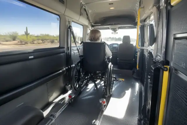 Dialysis transportation van interior with secure wheelchair tie-down bracket in Queen Creek, AZ.