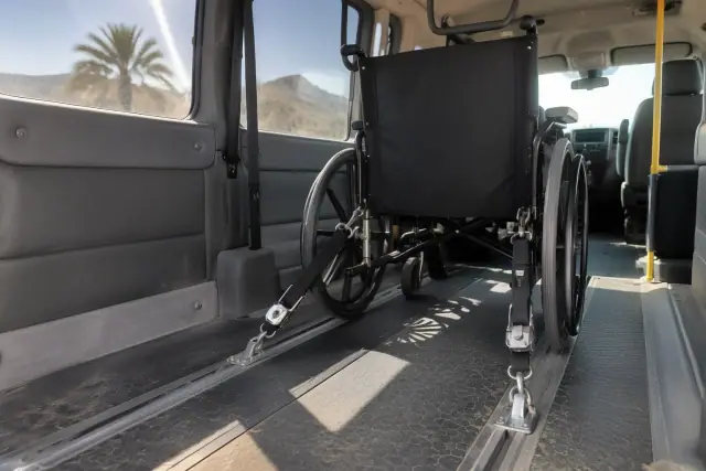 Four-point wheelchair tie-down straps secured to floor tracks in a transport van in Mesa, AZ.