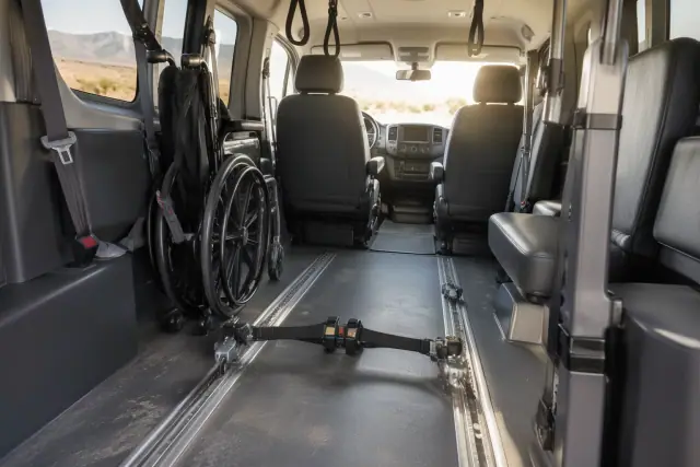 Wheelchair lockdown bracket and safety belt harness on the floor inside a transport van in Mesa, AZ.