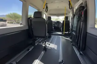 Desert landscape visible through the windows of a padded transport van interior in Mesa, AZ.