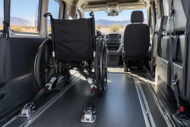 Inside a medical transport van in Chandler, AZ, showing wheelchair securement straps and an arid horizon.
