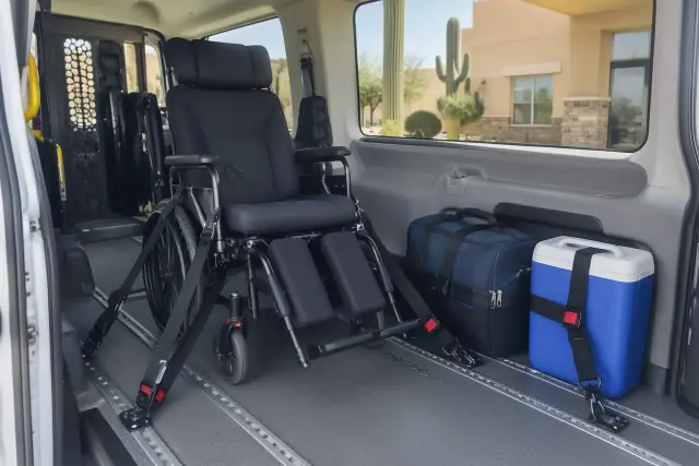 Van interior for long-distance medical transportation in Mesa, AZ, with a secured wheelchair and travel gear.