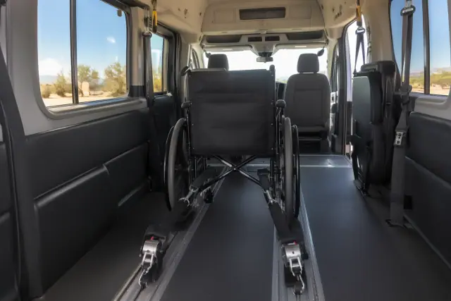 Wheelchair lockdown straps latched into floor tracks inside a medical transport van in Queen Creek, AZ.
