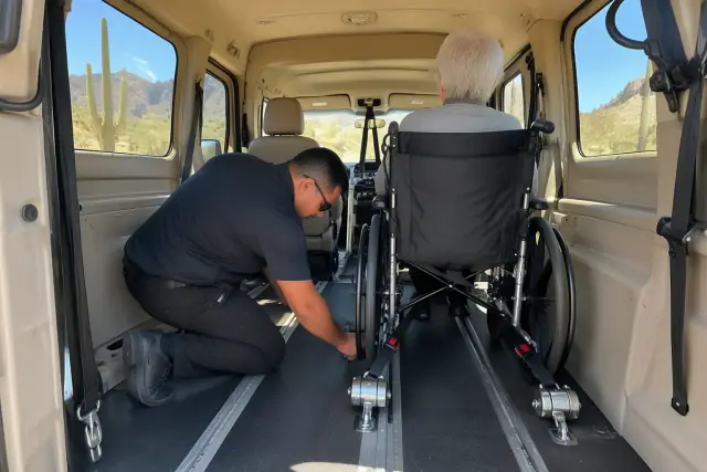 Medical transport van interior with secure wheelchair straps in Fountain Hills, AZ.
