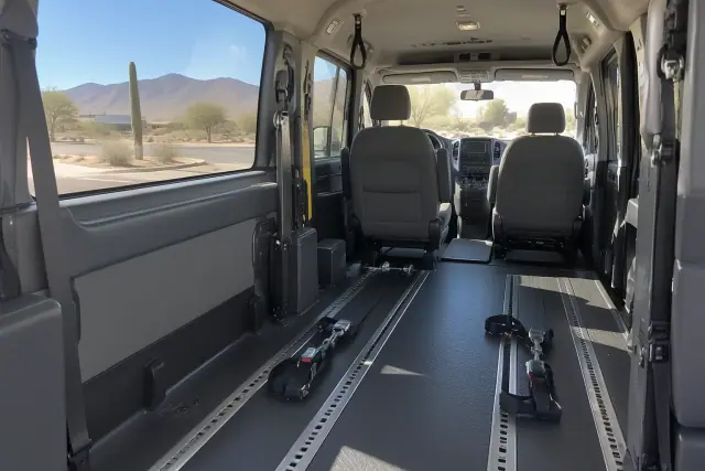 Wheelchair tie-down straps on the floor inside a medical transport van in Apache Junction, AZ.