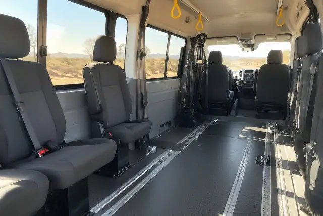 Medical transport van interior with padded seating and floor tracks in Chandler, AZ.
