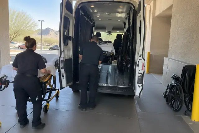 Medical transport van loading patient in Mesa, AZ, showing secure wheelchair tracks.