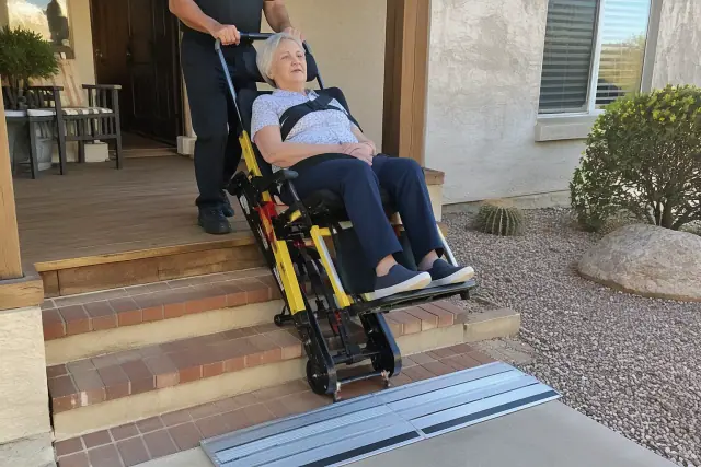 Stair chair transport on a wooden porch with brick steps and a ramp in Sun Lakes, AZ.