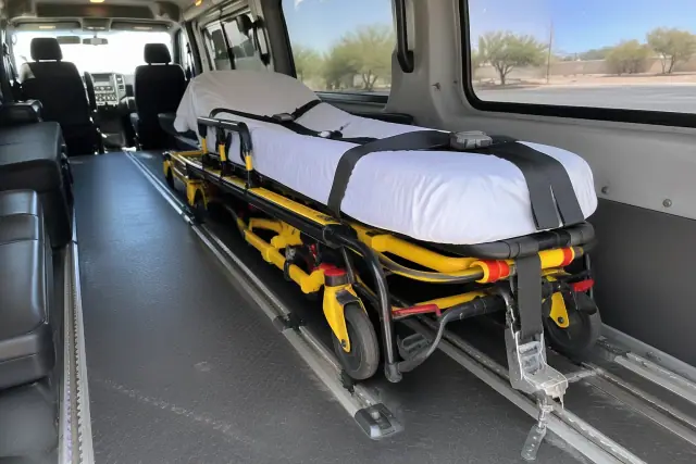 Collapsible wheeled stretcher secured inside a medical transport van in Tempe, AZ.