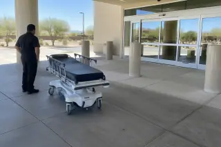 Service professional inspecting the clean transfer staging area of a stretcher and gurney transport vehicle in Mesa, AZ.