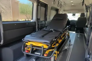 Padded transport van interior with overhead grab handles in Mesa, AZ.