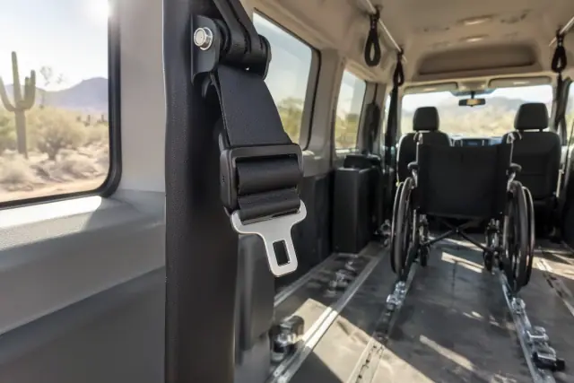 Adjustable wheelchair lap and shoulder restraint being installed inside a transport van in Mesa, AZ.