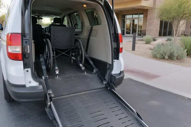 Accessible van with secured empty wheelchair at a dialysis clinic entrance in Mesa, AZ.