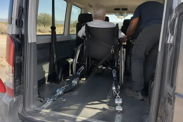 Wheelchair transport vehicle interior with secure tie-down brackets and safety harnesses in Mesa, AZ.