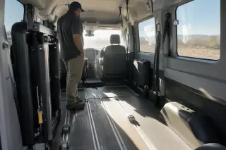 Driver checking the secure floor tracks inside a wheelchair transport van in Mesa, AZ.