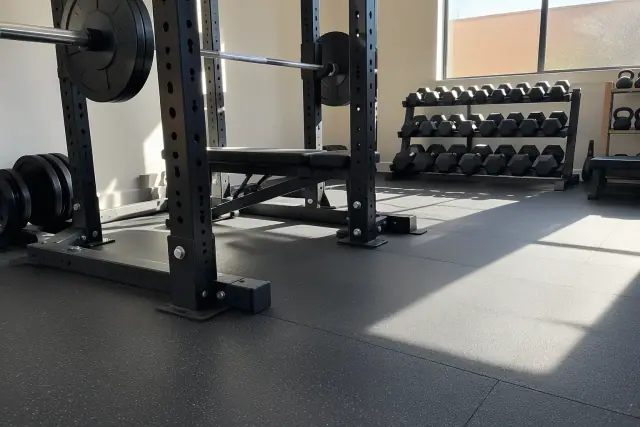 Heavy rubber flooring installed under barbell racks in a Chandler, AZ gym.