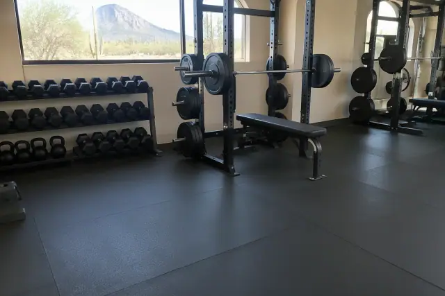 Black rubber flooring installed under heavy barbell racks in Paradise Valley, AZ.